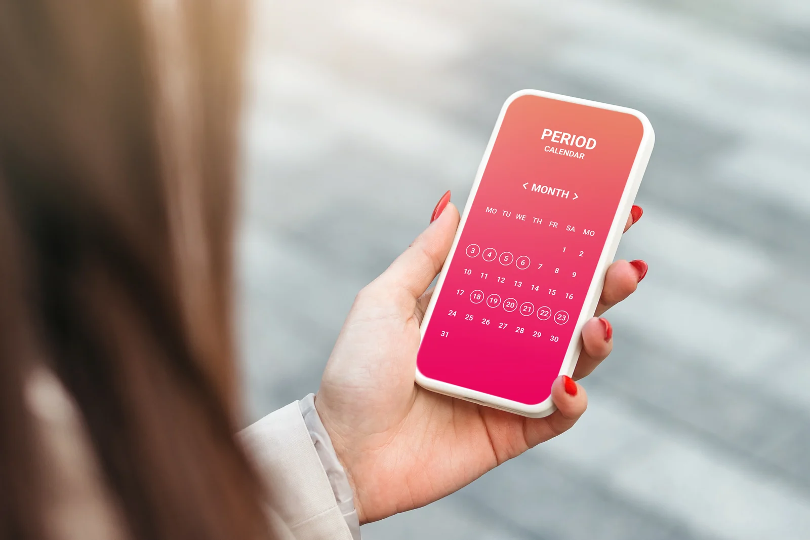 Woman holding a phone with a period calendar app to track cycle changes, an early sign of perimenopause for women in South Tempe, AZ.