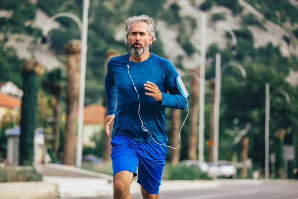 An active older man jogging outdoors, illustrating the cardiovascular and whole-body health that supports erectile function, part of the men's health approach at a South Tempe, AZ clinic.