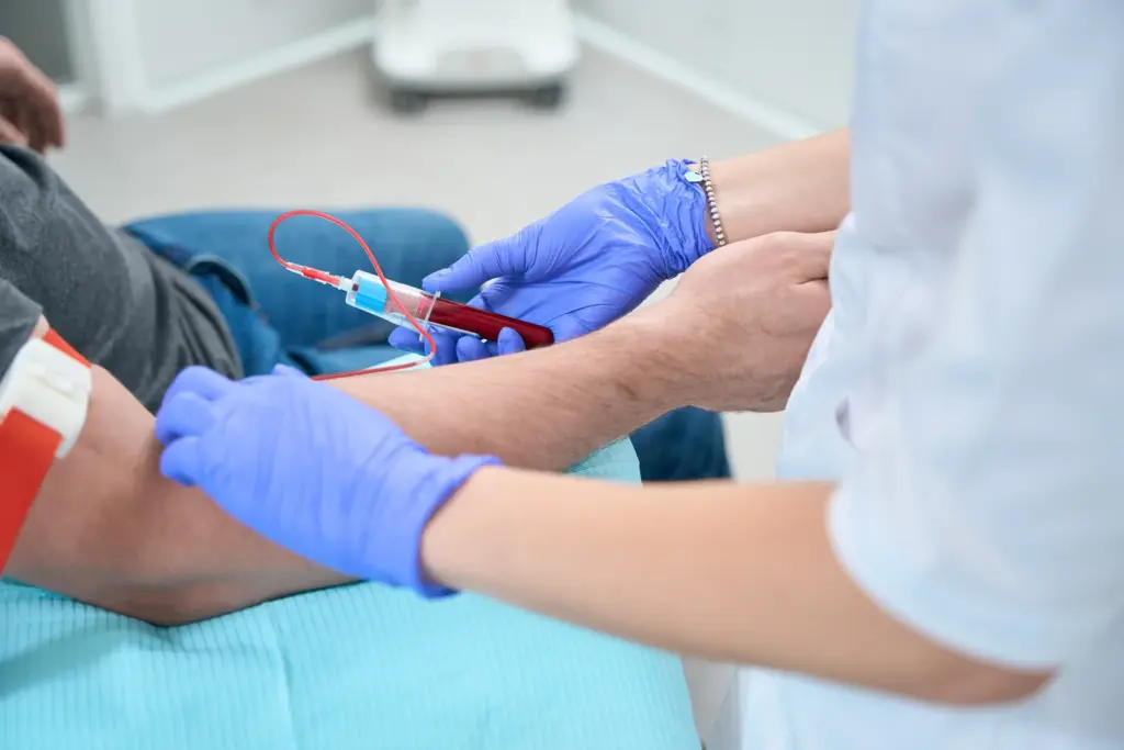 A gloved clinician draws blood from a patient arm for baseline lab work before a Tempe weight loss program.