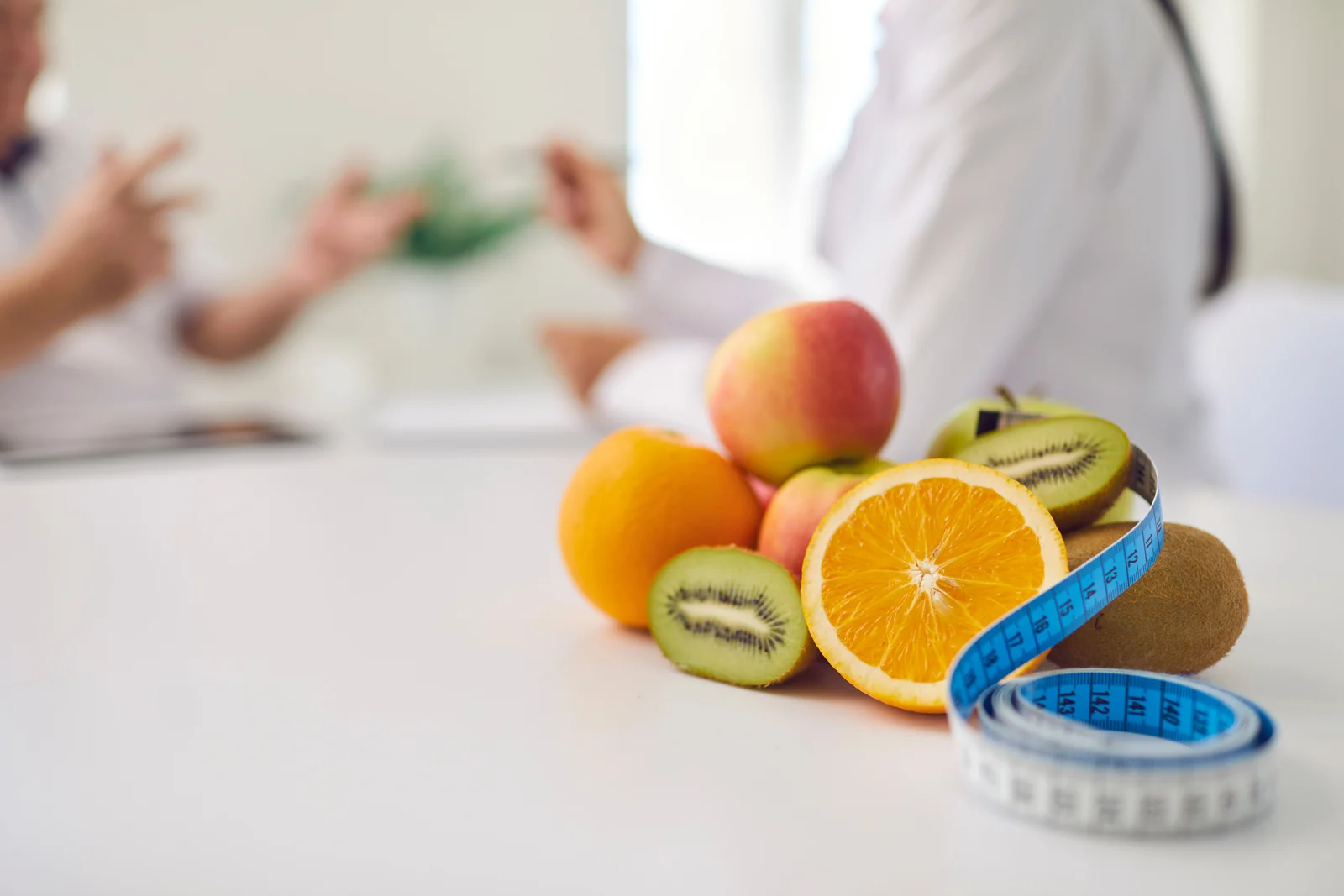 Fresh fruit and a measuring tape on a desk during a naturopathic weight loss consultation in South Tempe, AZ.