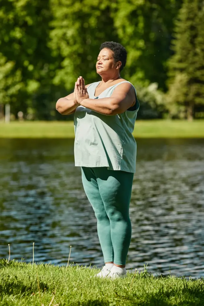 Mature woman meditating outdoors in warm sunlight, reflecting whole-body wellness for women after childbirth and menopause in Tempe.