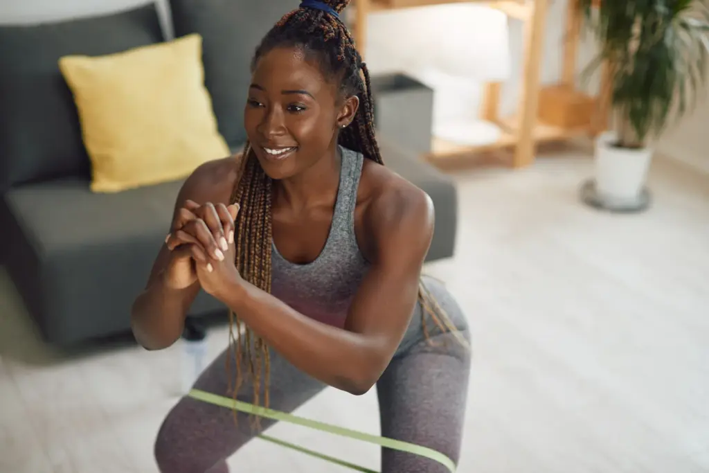 A woman doing resistance-band squats at home, showing the muscle-protecting activity that supports lasting results on semaglutide, guidance from South Tempe, AZ naturopathic physicians.