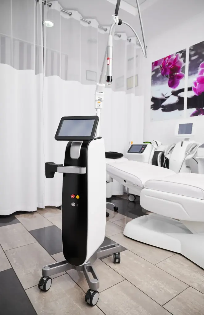 An RF microneedling device with a touchscreen console standing in a bright, clean treatment room, ready for a collagen treatment.