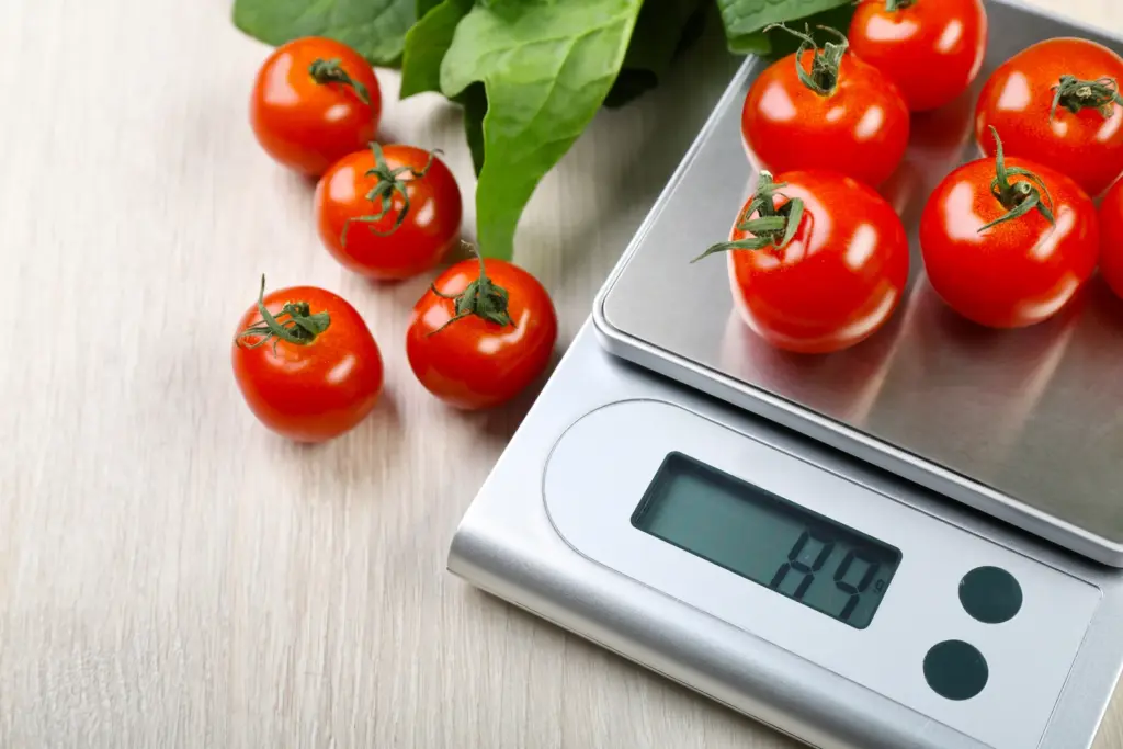 Cherry tomatoes on a digital kitchen scale, a simple portion tool for patients adjusting to a smaller appetite.