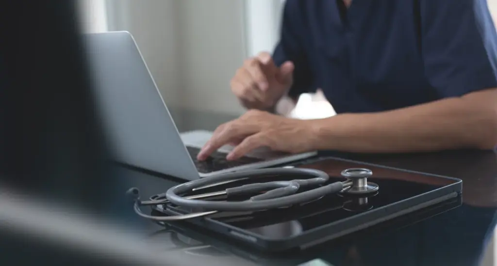 A clinician's desk with a laptop, tablet, and stethoscope, representing the medical supervision behind a semaglutide weight-loss plan at a South Tempe, AZ clinic.