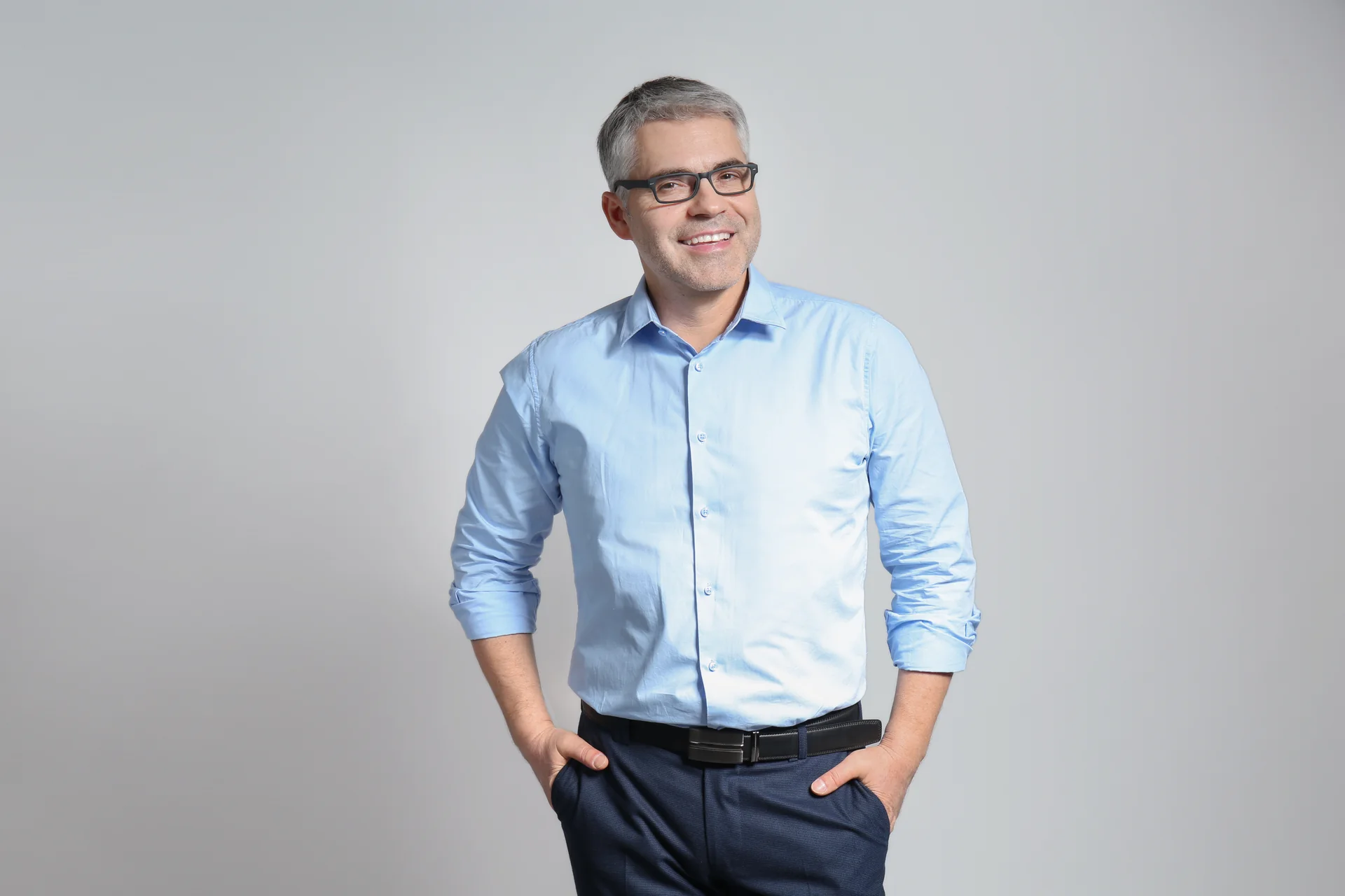 A confident mature man standing against a neutral background, representing the men's health focus of shockwave therapy for ED at a South Tempe, AZ naturopathic clinic.