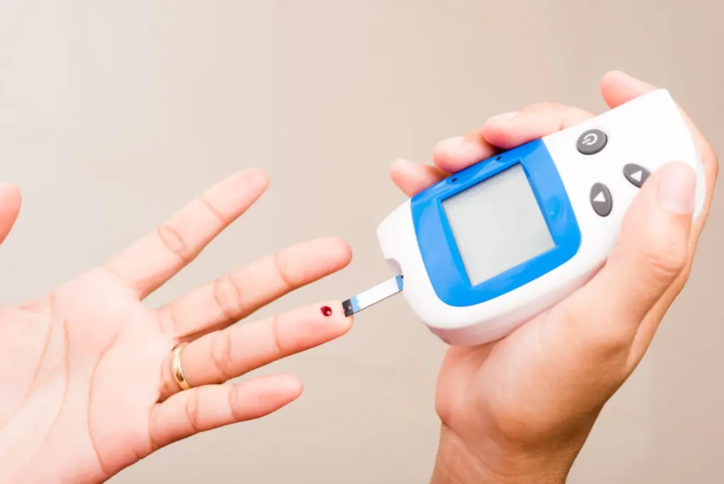 Hands use a glucometer for a fingertip blood sugar check, one of the metabolic markers tirzepatide can influence.