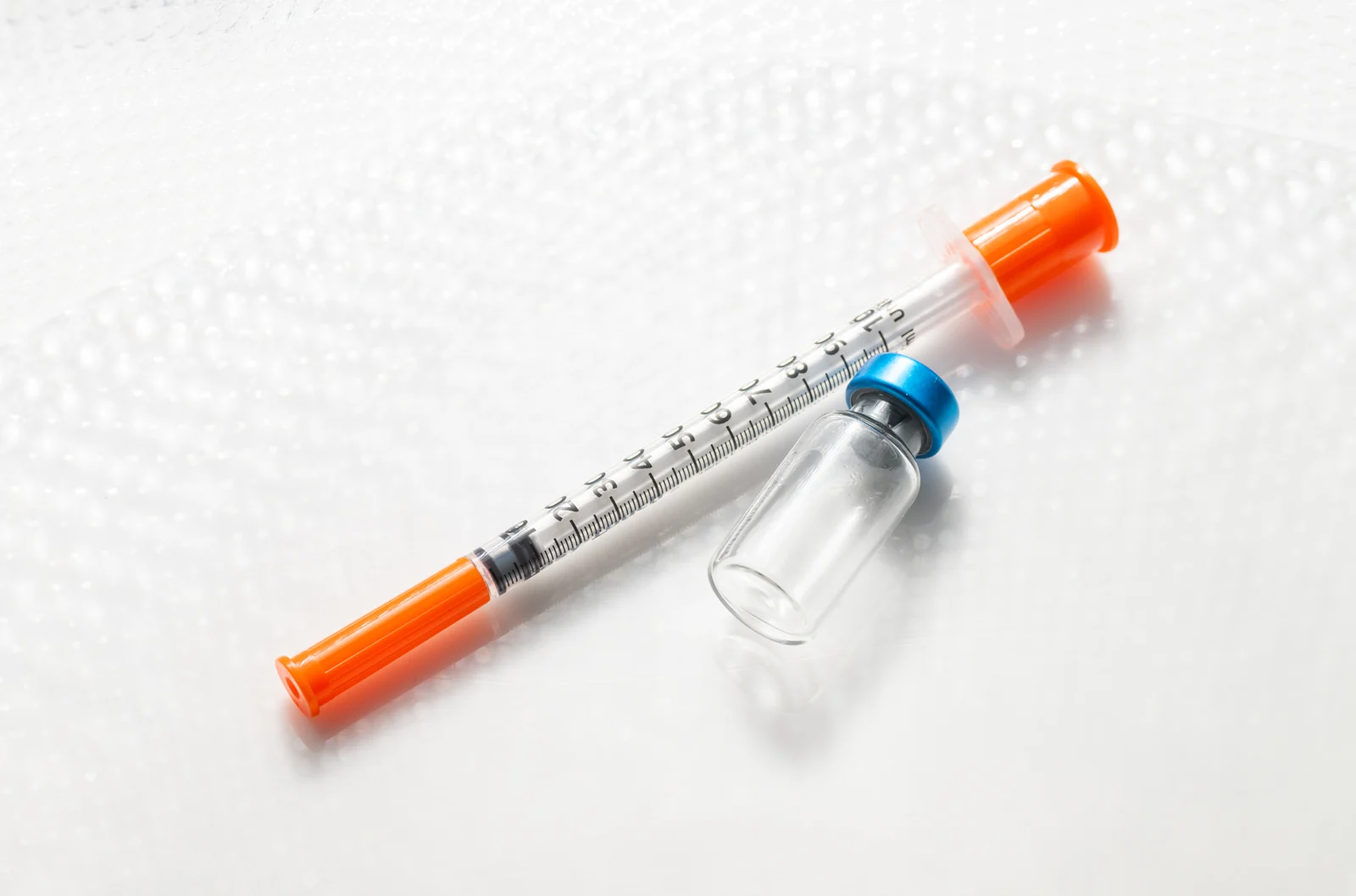 A clear medication vial beside a single-use syringe, representing supervised tirzepatide weight management in South Tempe, AZ.