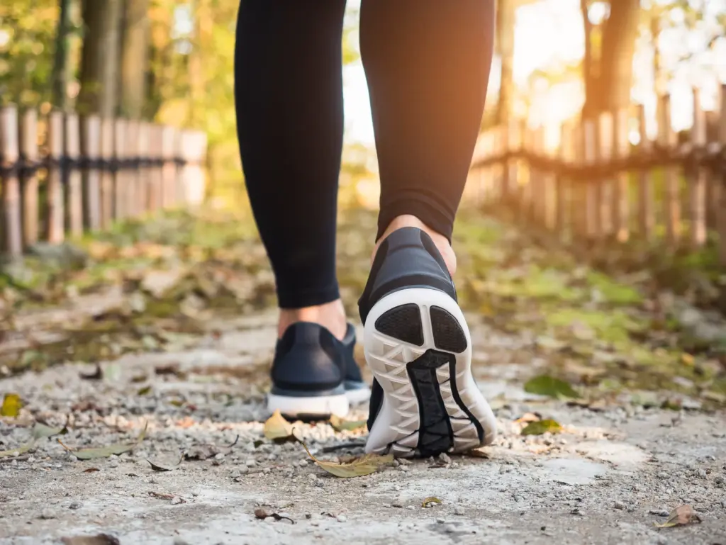 A walker in sneakers on a sunlit dirt trail, a daily movement habit that supports a tirzepatide plan in Tempe.