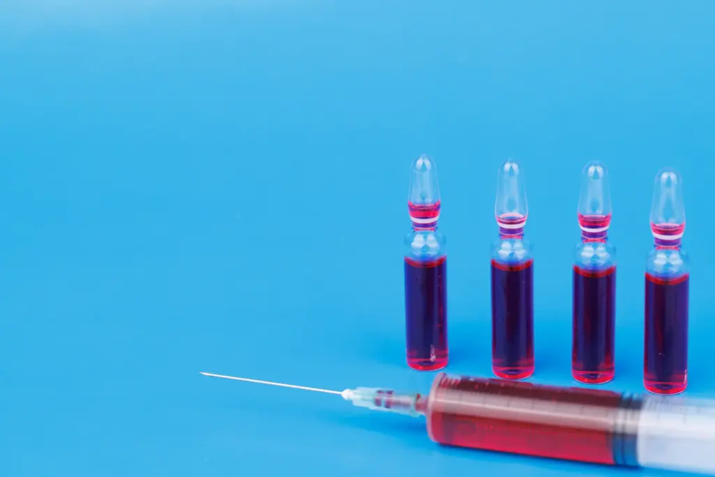 Red vitamin B12 ampoules and a filled syringe, the type of nutrient injection used alongside a weight loss plan.